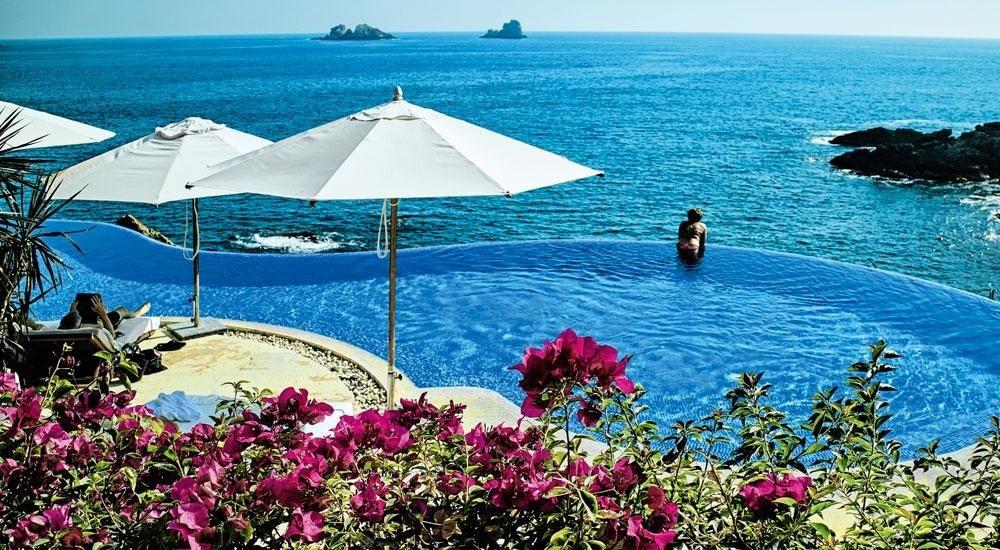 In dit resort op Ixtapa lijkt het zwembad over te gaan in de oceaan.