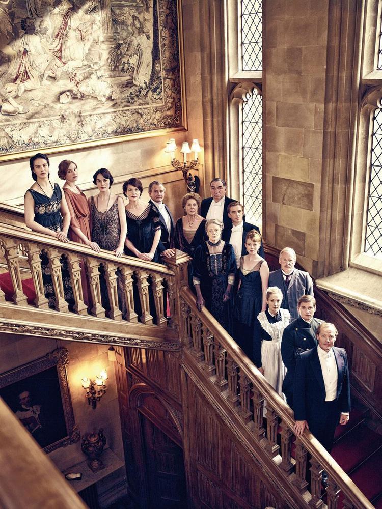 De cast van Downton Abbey op de statige eiken trap van Highclere Castle