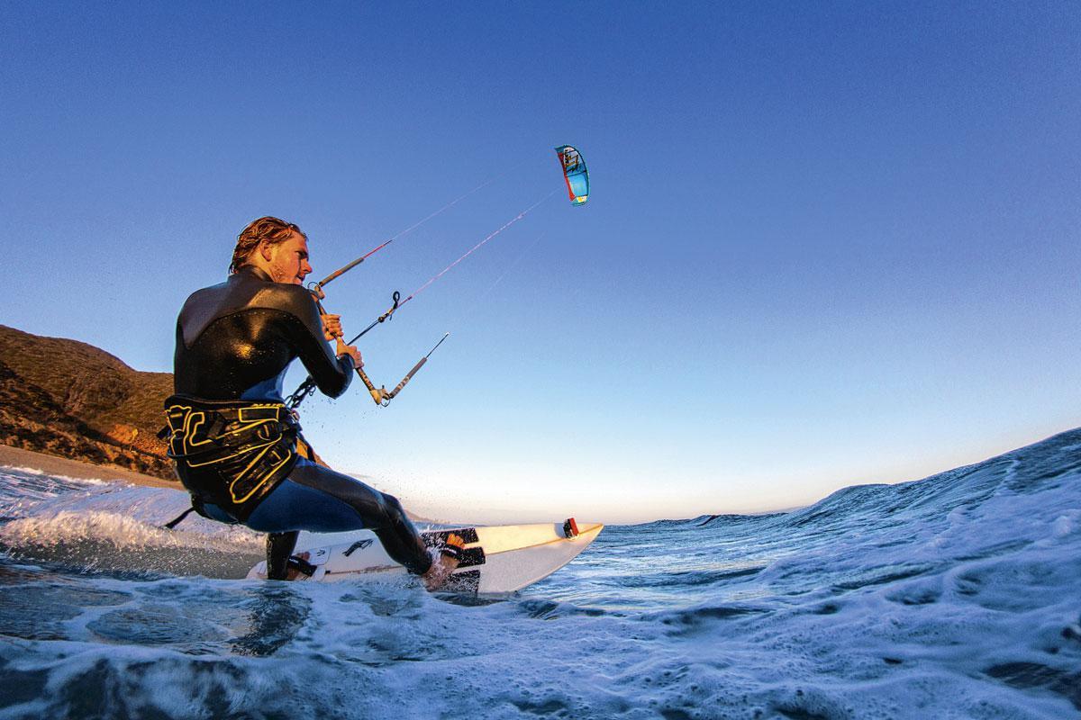 Een surfplank, een vlieger en de ondergaande zon. Meer heeft deze kitesurfer in Malibu niet nodig.