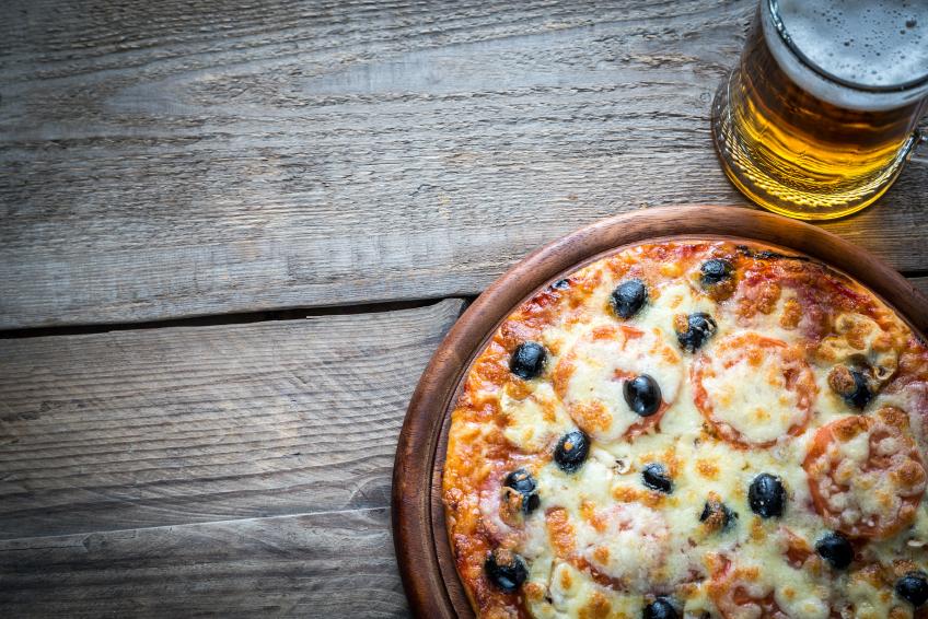 Cooked pizza with a glass of beer