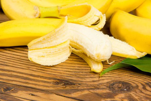 Photo of peeled bananas on wooden board