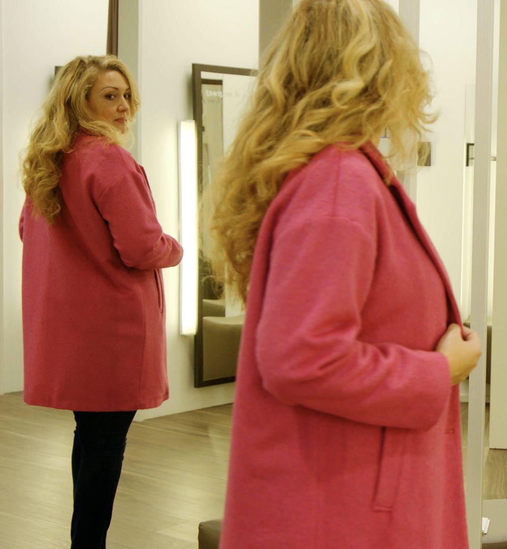 Béatrice essaie un manteau rose.