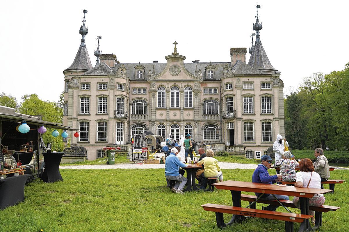 Het kasteel met Franse tuin ervoor en picknickbanken.