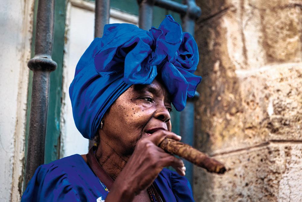 Een alledaags tafereel in de straten van de Cubaanse hoofdstad, waar de sigaar geen luxeproduct is maar een massaconsumptiegoed... met de omvang van een tafelpoot.