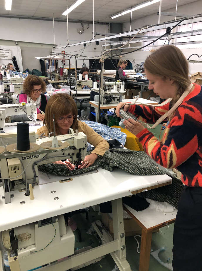 Een naaiatelier in Portugal. Er zitten vrouwen achter naaimachines te werken.