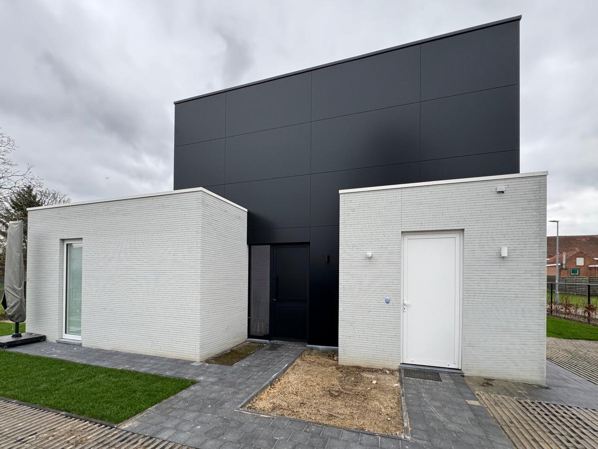 Voor de gevel werd gekozen voor een combinatie van een aluminiumcomposietplaat en een gevelsteen in beton.