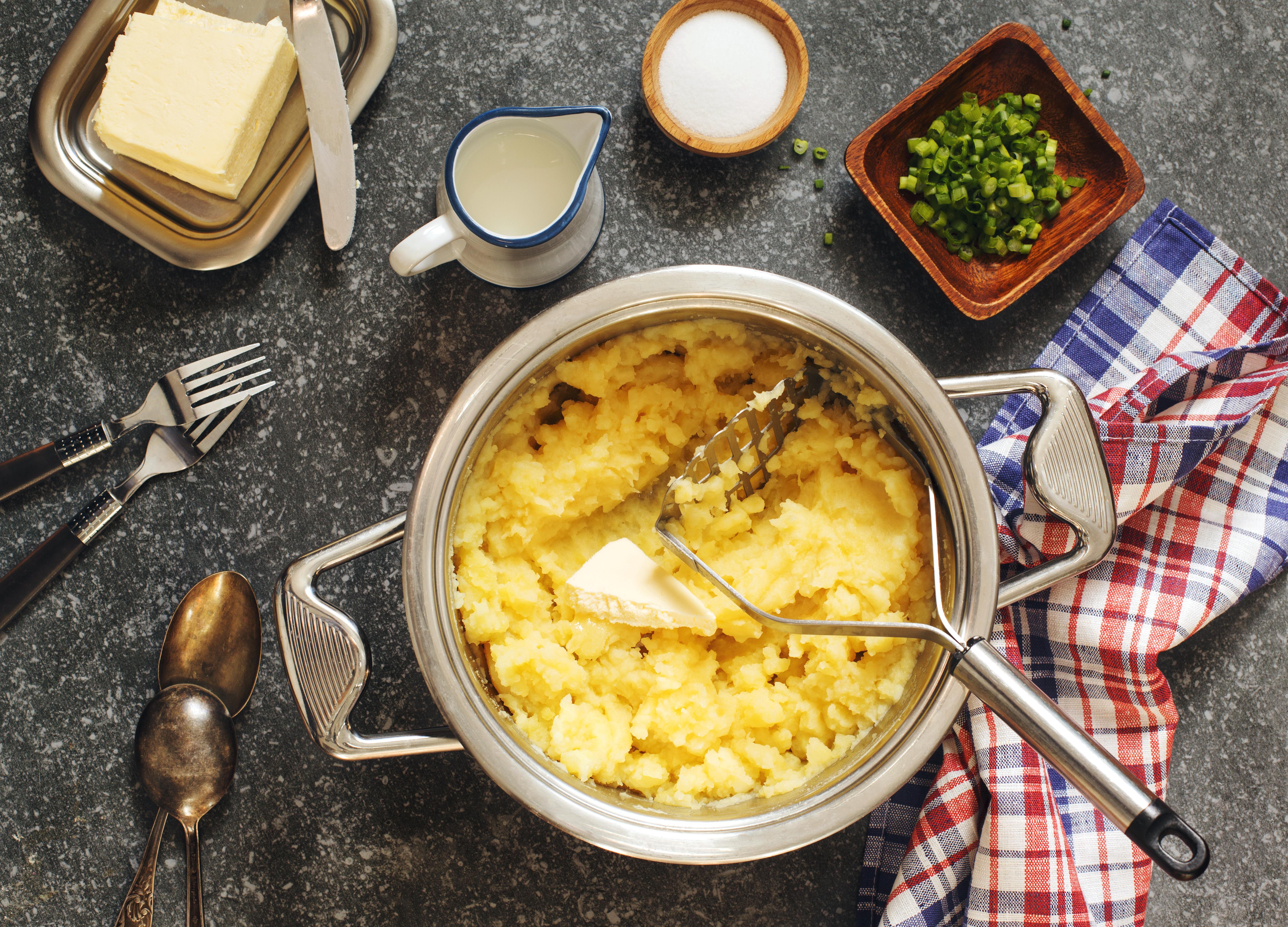 Mashed potato in cooking pan on wooden table