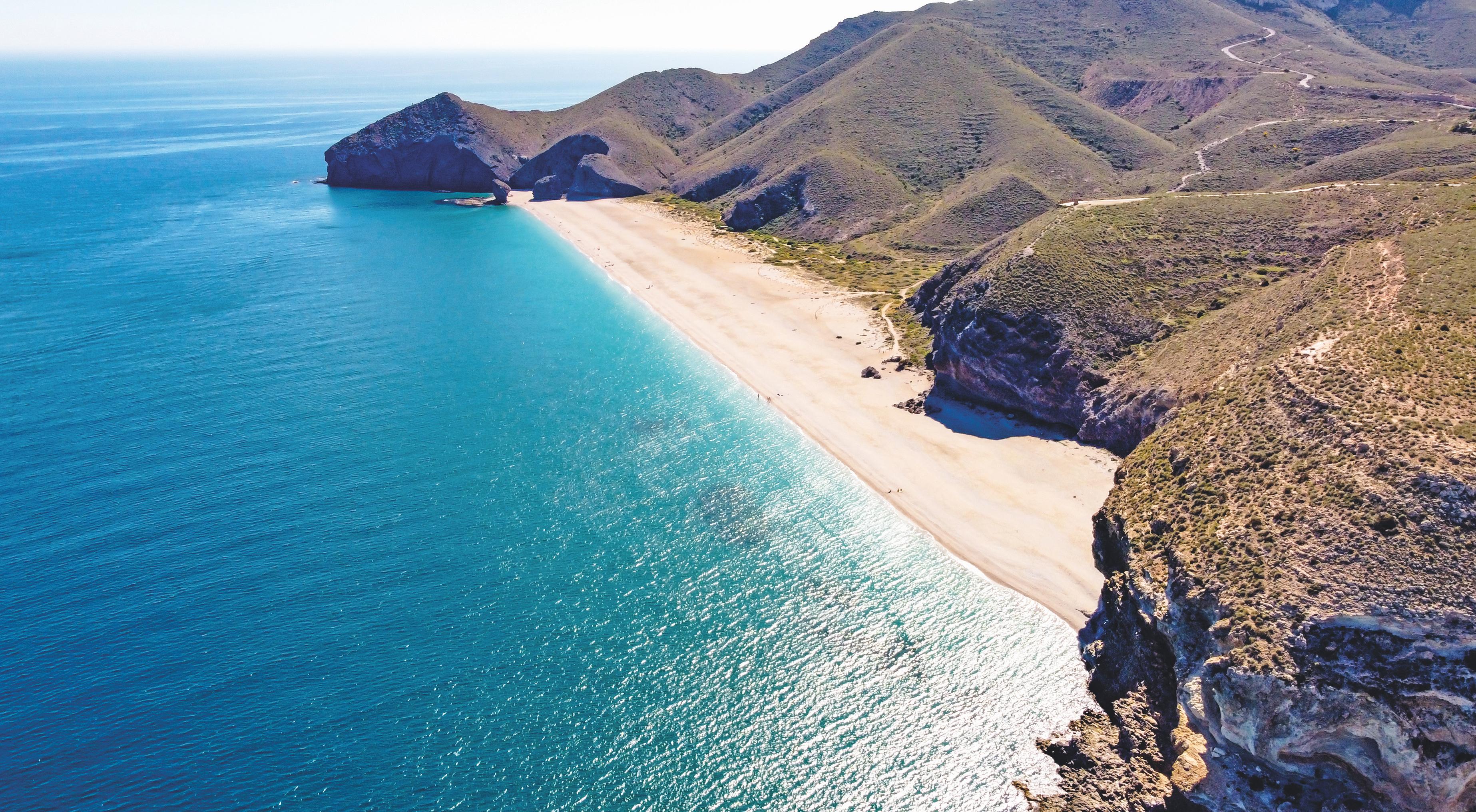 Seashore, coastline, scenic view of people at unspoiled beach in Almeria, called Playa de los Muertos, in English The beach of Deads due to the strong currents that cause many deaths year after year