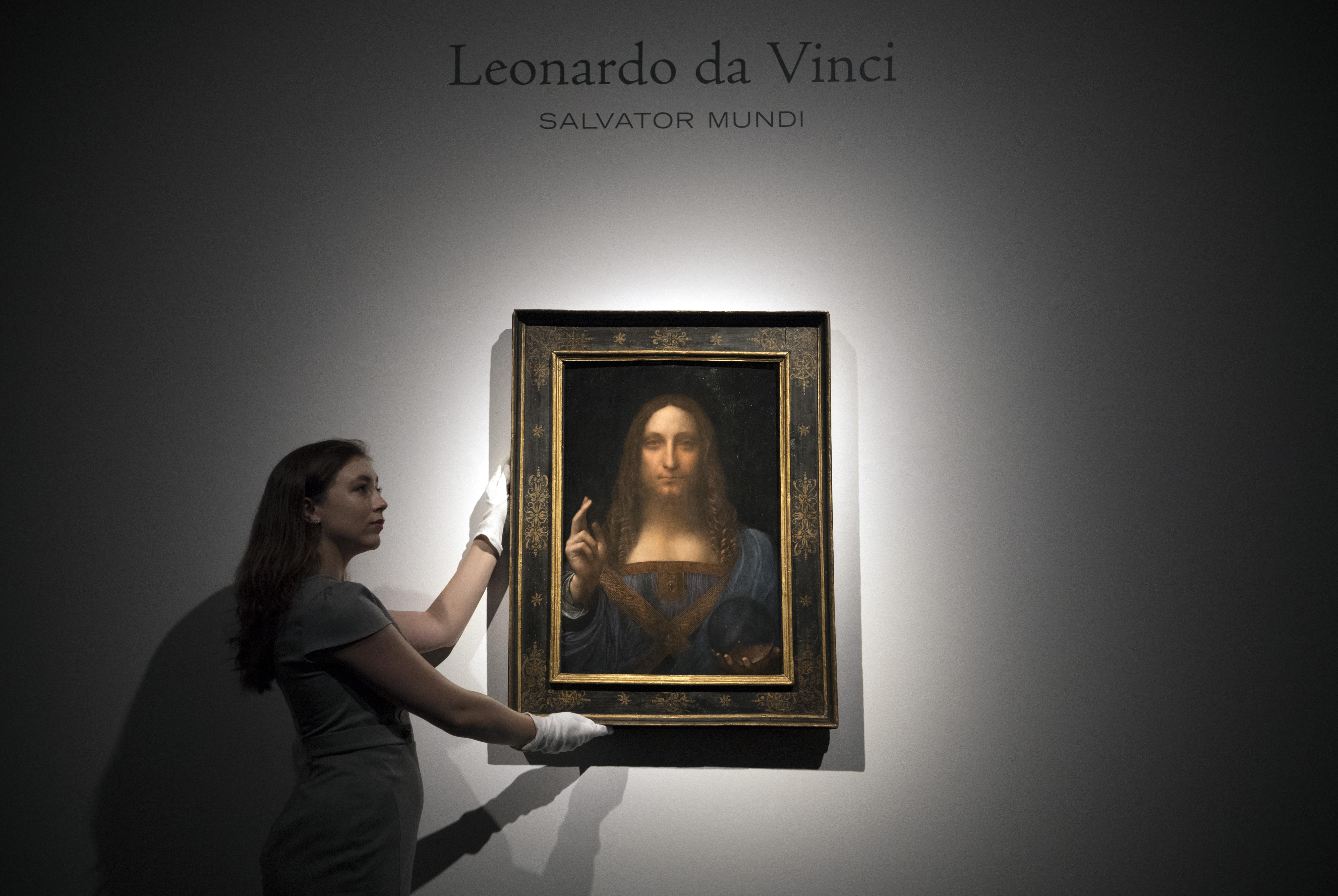Een medewerker van Christie's met de 'Salvator Mundi' van Leonardo da Vinci.