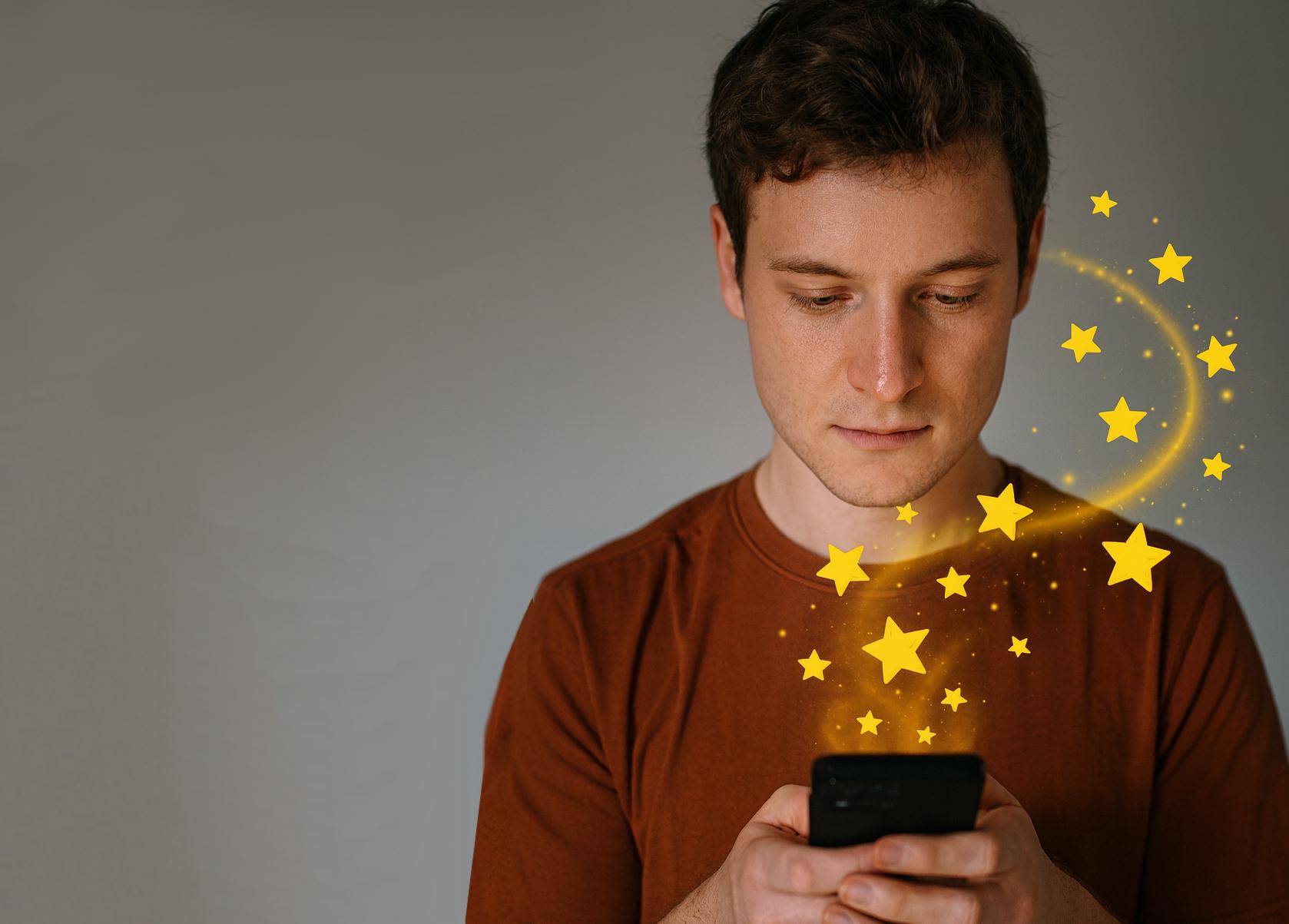 photo personne consultant un smartphone avec des étoiles qui sortent de l'écran