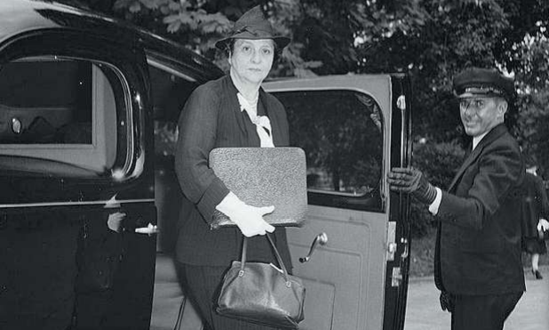 Foto waarop Frances Perkins, de eerste vrouwelijke minister van de VS, uit een auto stapt