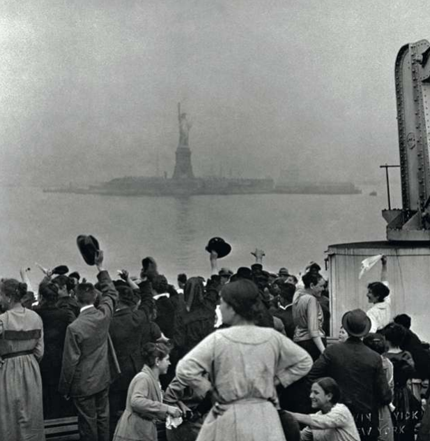 Migranten staan te kijken naar het Vrijheidsbeeld