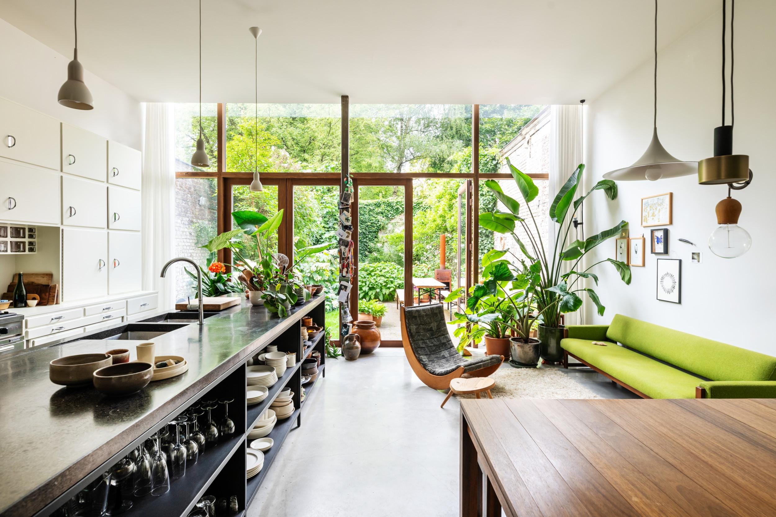 De volumineuze uitbouw van de rijwoning ontwierp Karolien zelf. Zeven meter brede raampartijen geven uit op de grote groene tuin.