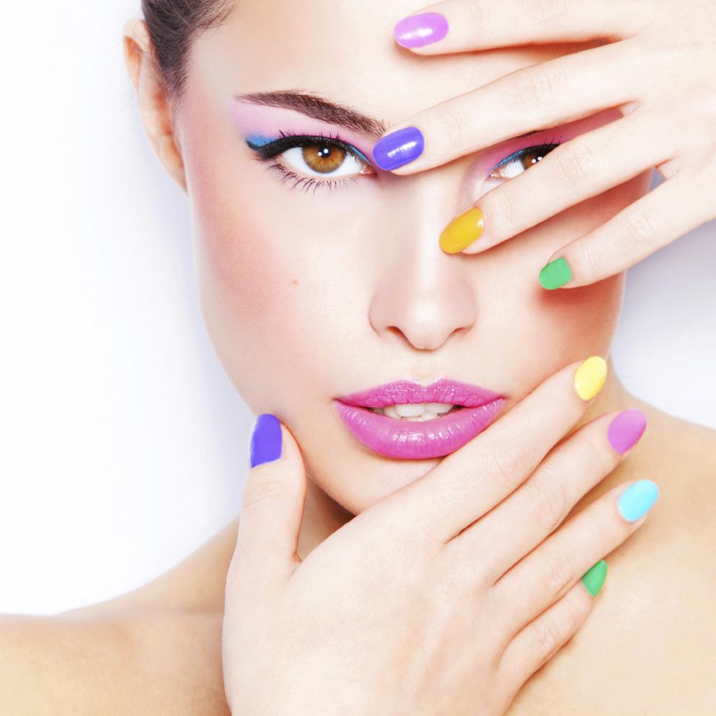 young woman portrait with colorful makeup and nail polish, studio white