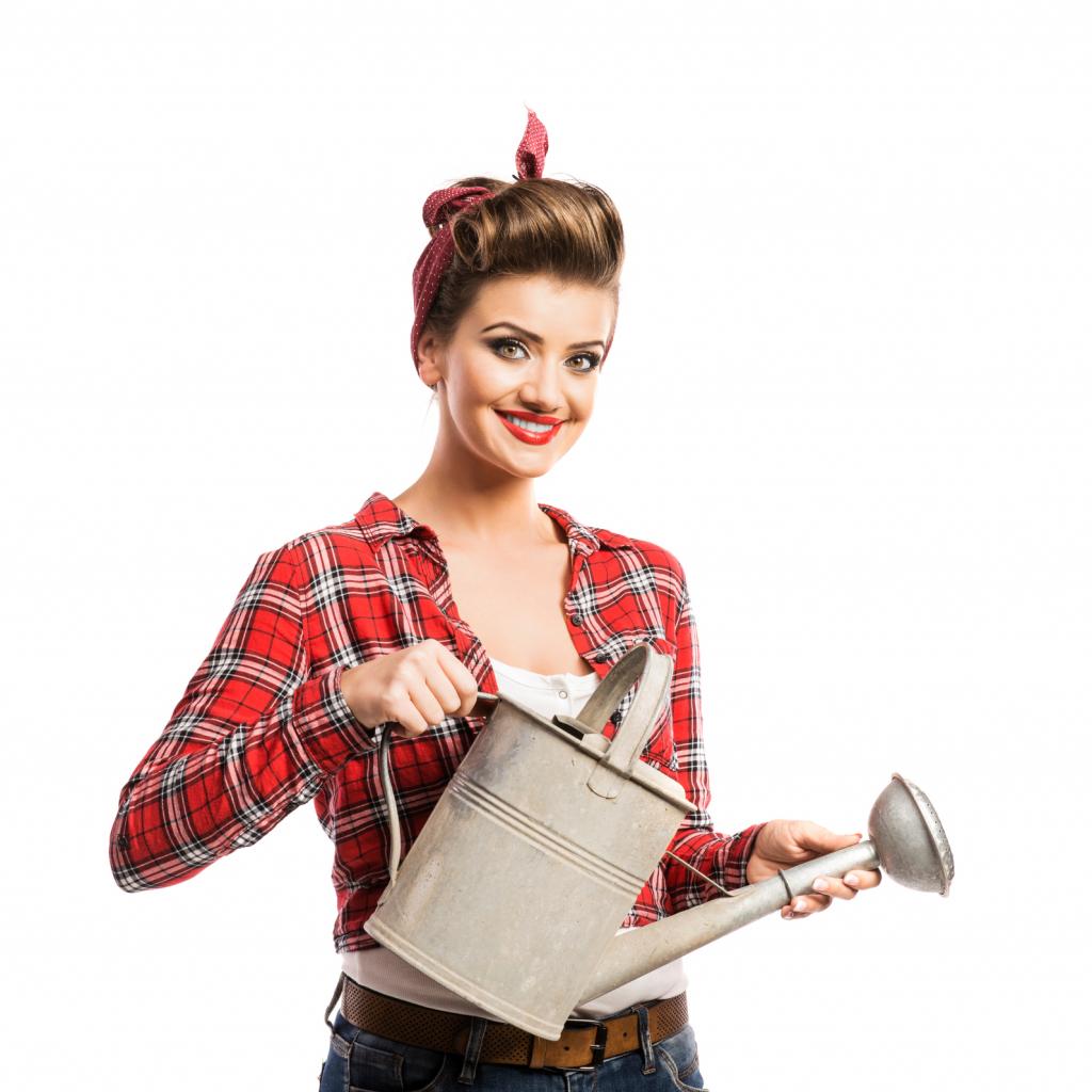 Woman with pin-up make-up and hairstyle holding metal watering c