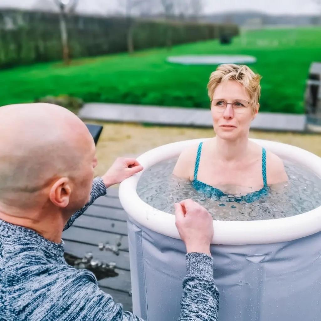 Vrouw van middelbare leeftijd neemt ijsbad met begeleider