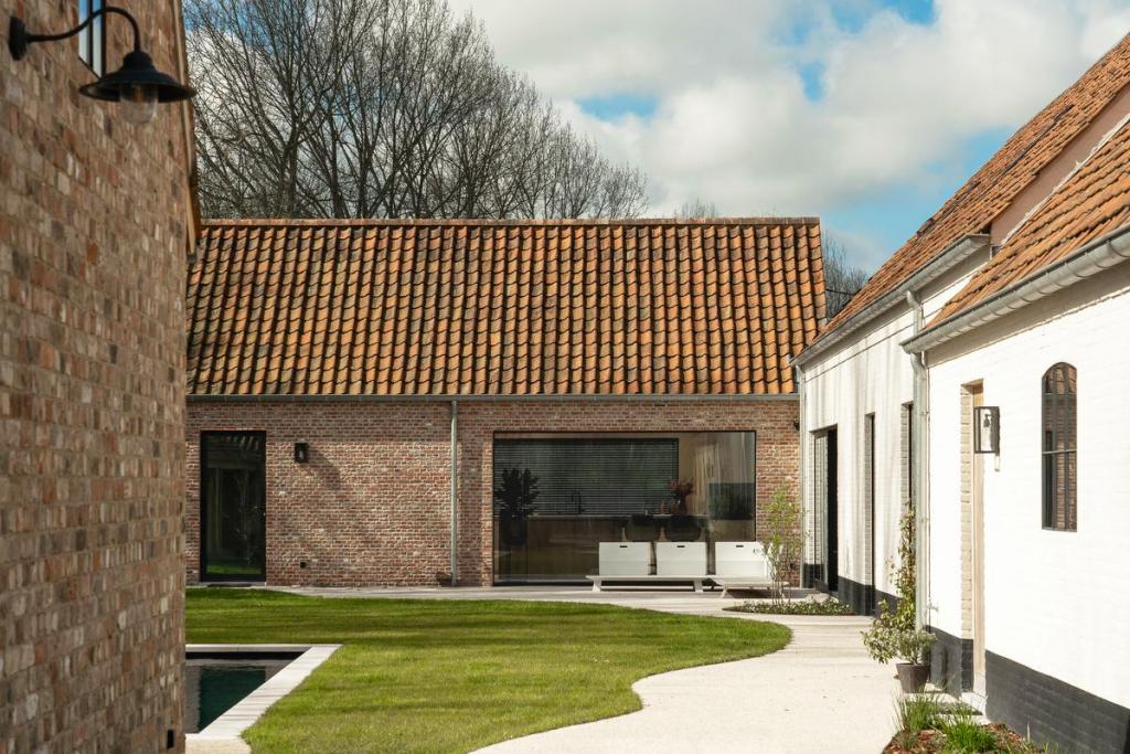 De leefruimte staat in directe verbinding met het bijgebouw, waar de keuken zich bevindt.