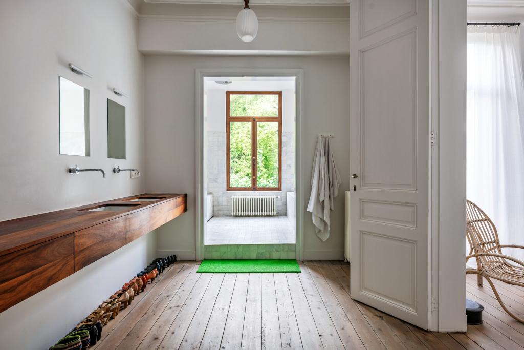 Rijoning Gent - Het wastafelmeubel in padoek is even lang als de muur en biedt veel opbergruimte. De badkamer lijkt op een hamam.