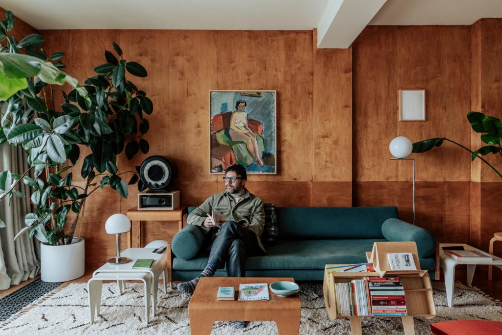 Tom Broughton op de sofa van Robin Day voor Hille. Schilderij van John Ivar Berg.