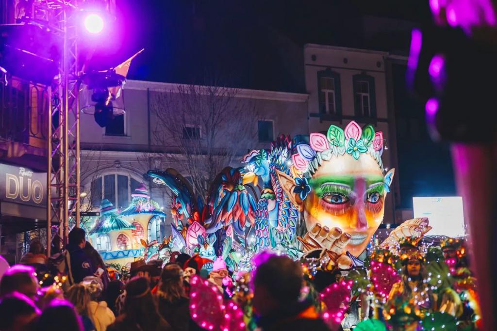 Carnavalsstoet tijdens de nacht met kleurrijke praalwagens en veel licht.