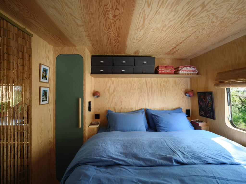 De  slaapkamer in de woonwagen is knus en praktisch, maar ook verrassend ruim. Aan het voeteinde is plaats voorzien voor een minidressing.