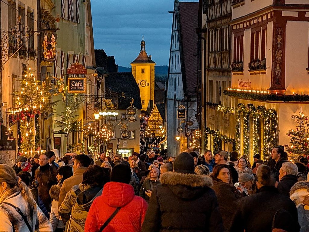 De lokale bevolking en toeristen genieten van een avond in de feestelijk verlichte oude stad en op de kerstmarkt.