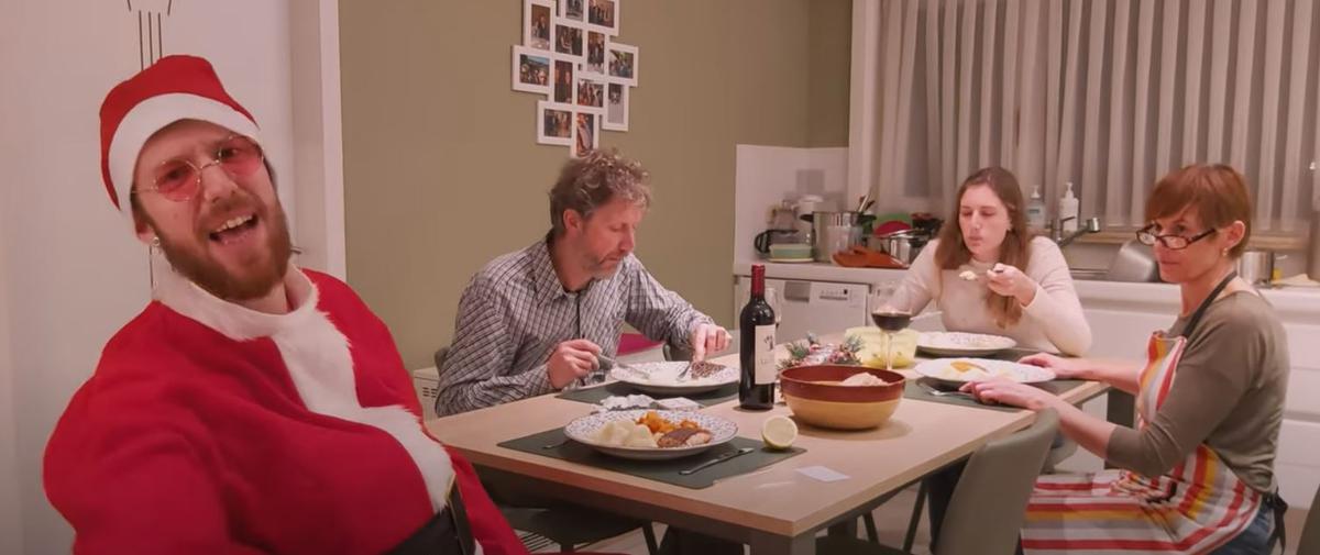 Rappende kerstman ‘eRNA’ aan tafel met zijn vader Wim, zus Hanne en moeder Karien.© Screenshot YouTube