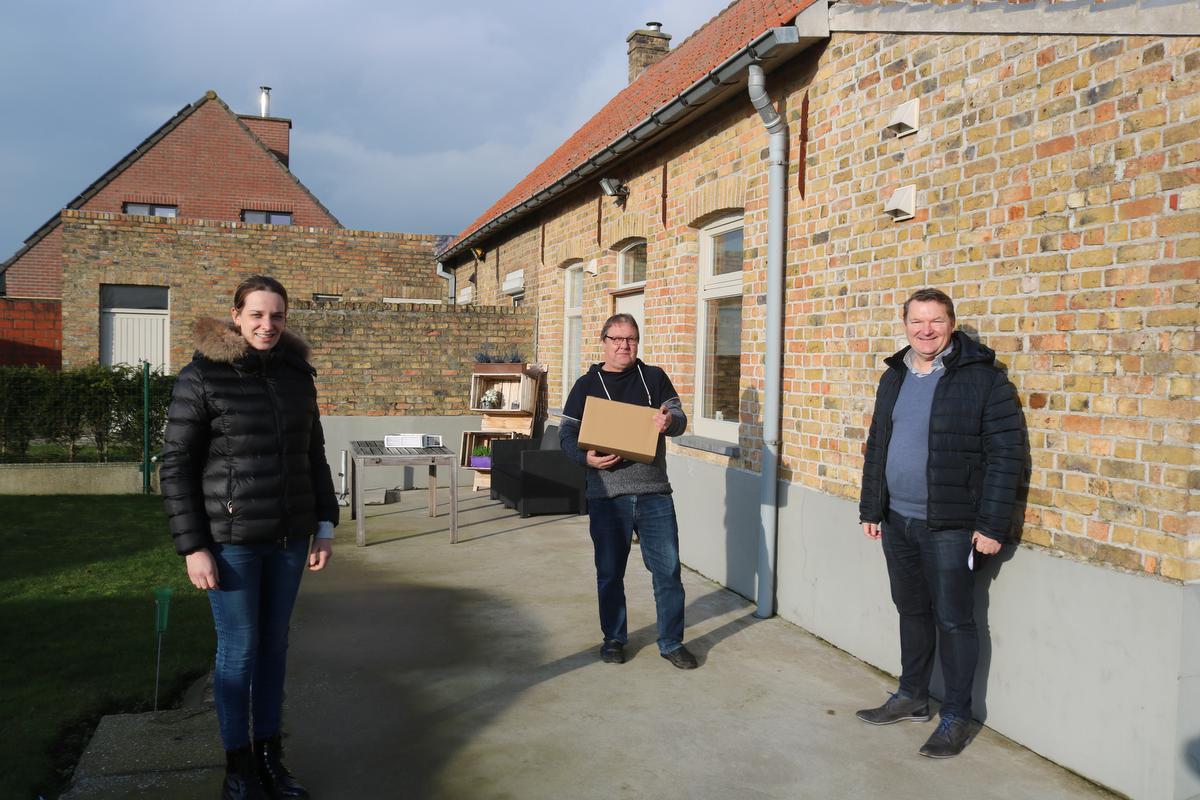 We zien op de foto vlnr schepen Tessa Vandewalle, medewerker van de gemeente Jean-Marc Dehoorne die zijn feestbox ontving en burgemeester Joris Hindryckx die samen met schepen Vandewalle de box rondbracht.©type=