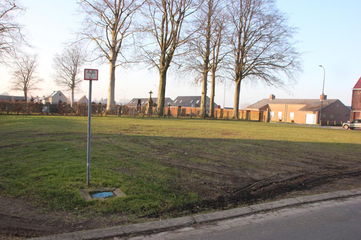 Het grasveld aan het kerkhof zou in de toekomst als parking een oplossing kunnen bieden voor het parkeerprobleem rond de school.© (Foto JG)