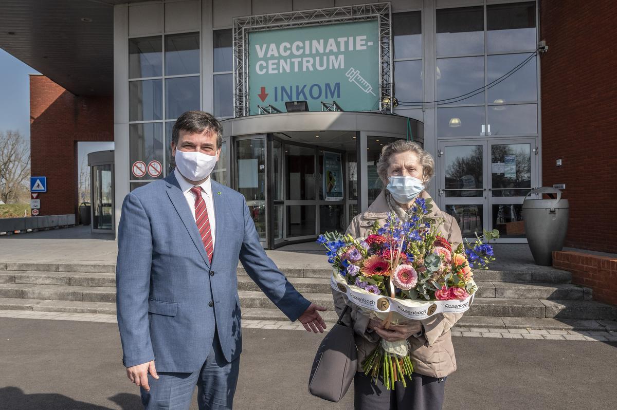 Burgemeester Kris Declercq overhandigde een boeketje aan Jacqueline, zij kreeg de 5.000ste vaccinatie in het Roeselaas vaccinatiecentrum.© Stefaan Beel