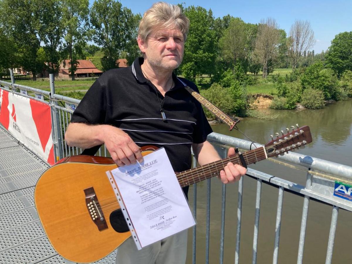Steffen Ron aan de Leie-brug met liedteksten.