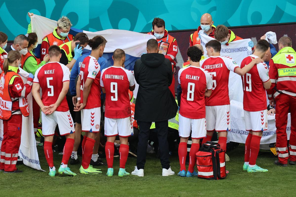 De spelers van Denemarken verzamelen rond Christian Eriksen tijdens de match tegen Finland op 12 juni 2021.©WOLFGANG RATTAY AFP