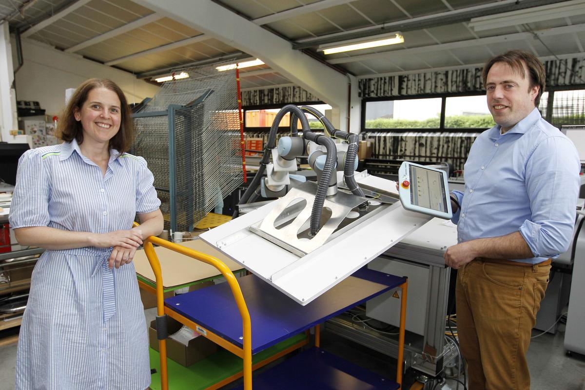 Zaakvoerders Carmen Vermeersch en Jan Oost bij hun intelligente, mobiele ‘derde arm’.© foto Coghe