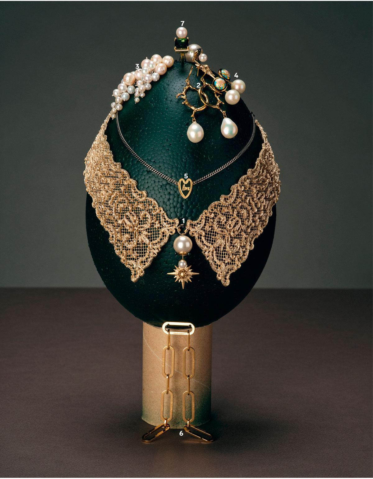 Collier doré D-Renaissance et boucle d’oreille dorée ornée d’une perle en résine et d’une étoile (1), Dior. Créoles avec aiguilles et grande perle (2), Wouters & Hendrix. Boucles d’oreilles en or jaune 18 carats et petites grappes de perles (3), Anne Zellien. Boucle d’oreille pendante avec perles et motif fleuri (4), Freywille. Chaîne fine dorée avec pendentif cœur (5), Anna+Nina. Bracelet à maillons en or 18 carats (6), Dinh Van. Bague Lustre en or 18 carats avec tourmaline, perle et diamant (7), Lore Van Keer.