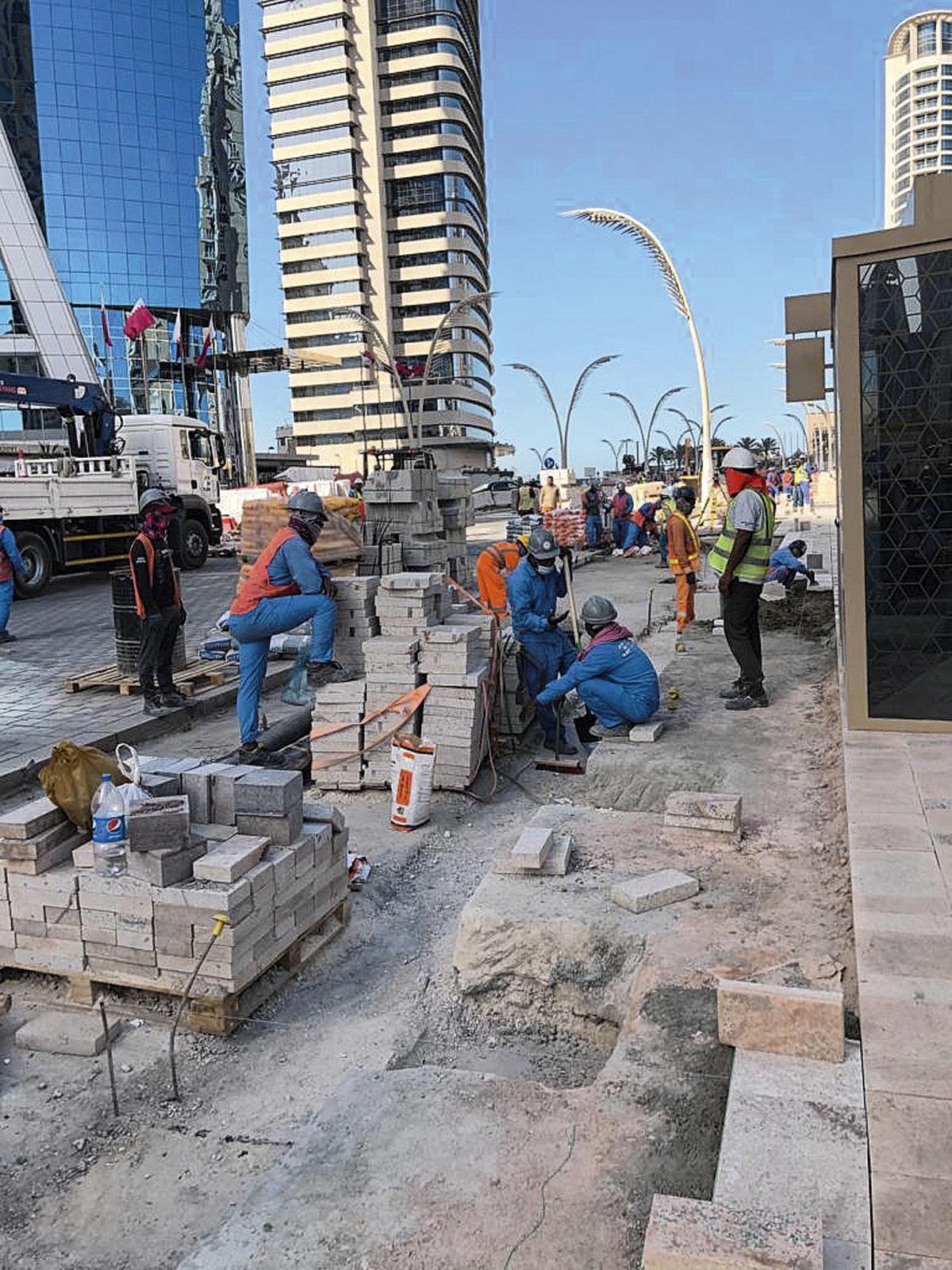 Des travailleurs étrangers à l'ouvrage à Doha. La plupart d'entre eux seront renvoyés chez eux durant la Coupe du monde, pour donner un aspect plus "soigné" au paysage.