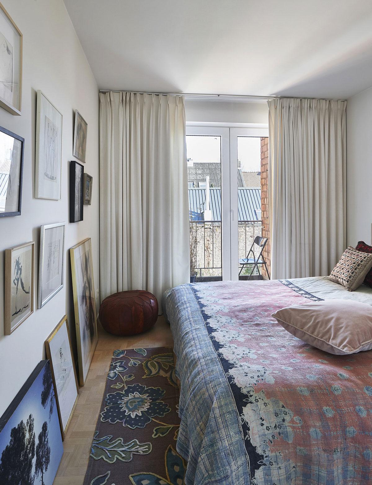 De slaapkamer, een romantische cocon met een muur vol grafiek van bevriende kunstenaars, kijkt uit op de historische Gentse Machariuswijk.