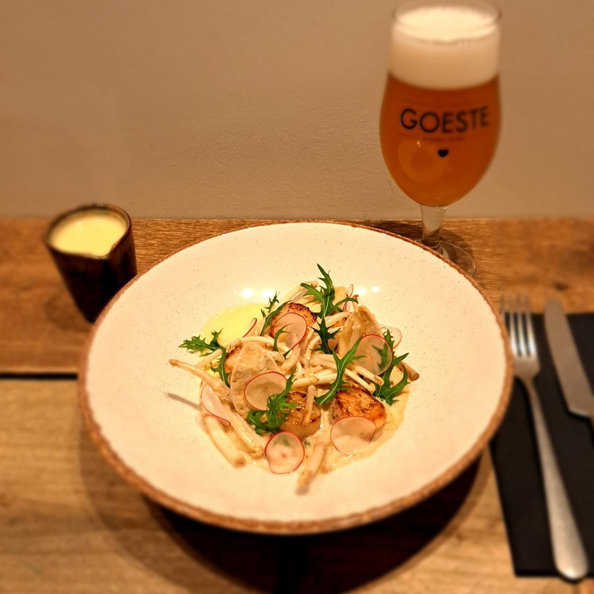 Chef Louis heeft een lekker gerecht voorbereid: gebakken sint-jacobsnootjes, karnemelkstampers, gerookt spek, hopscheuten in de room en lichte mousseline van St. Bernardus tripel.