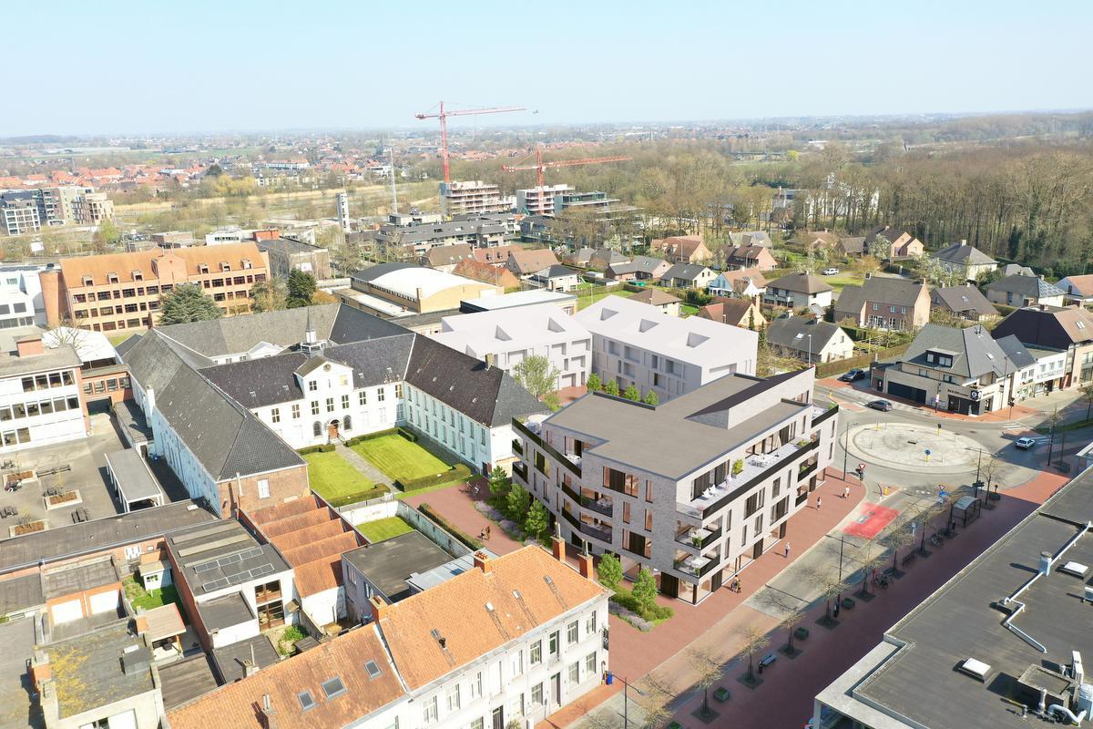 Het nieuwe appartementsgebouw dat Immo Bossu begin volgend jaar bouwt zie je op deze simulatie in het verlengde van de linkervleugel (rechtervleugel als je naar de foto kijkt) én aan de kant van de Gentsestraat, vlak bij het rond punt aan de Dirk Martenslaan.
