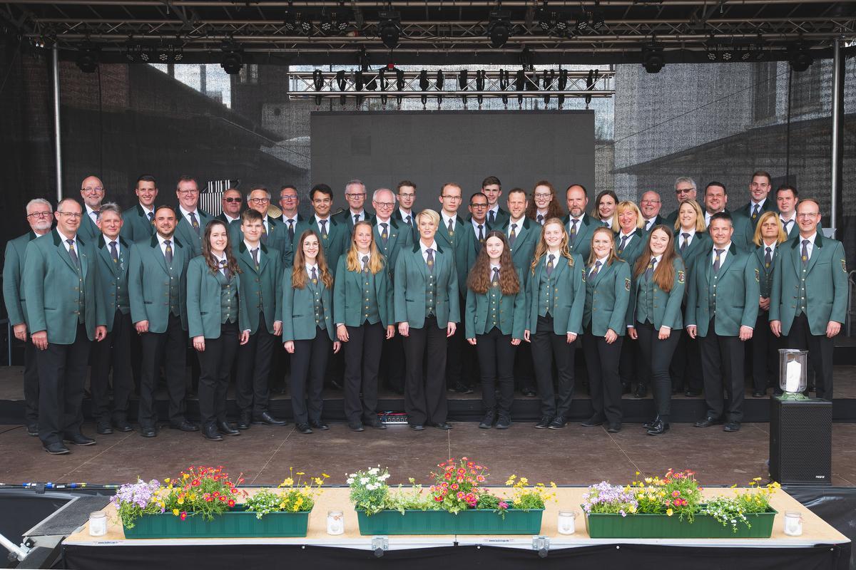 Een groepsfoto van Musikverein Niederense die op zondag 30 april van 11 tot 15 uur een aperitiefconcert zullen brengen op het Stationsplein.