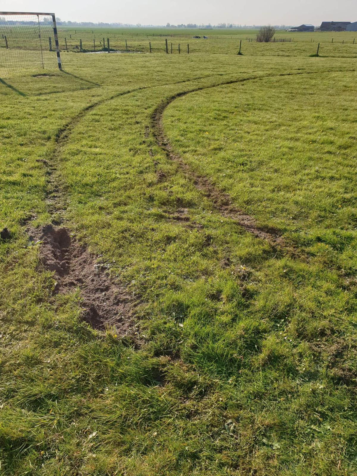 Er zijn duidelijke sporen te zien van een wagen die over het grasveld heeft gereden.