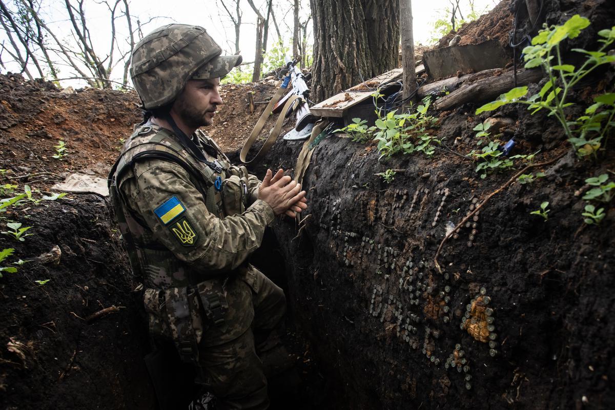 Een Oekraïense soldaat verschuilt zich in een loopgraaf nabij de stad Bachmoet.