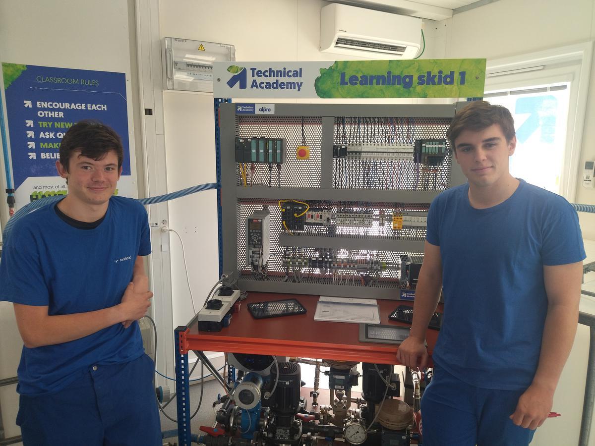 Stephen Delemar (links) en Cédric Vandenbulcke (rechts) bij hun skid, een installatie die het bedrijf na hun bachelorproef zal gebruiken.