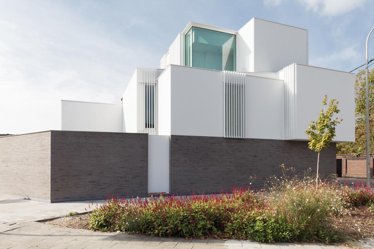 Op de massieve bakstenen sokkel kwam een eerder luchtige bekroning in witte buitenpleisterafwerking.©Annick Vernimmen 