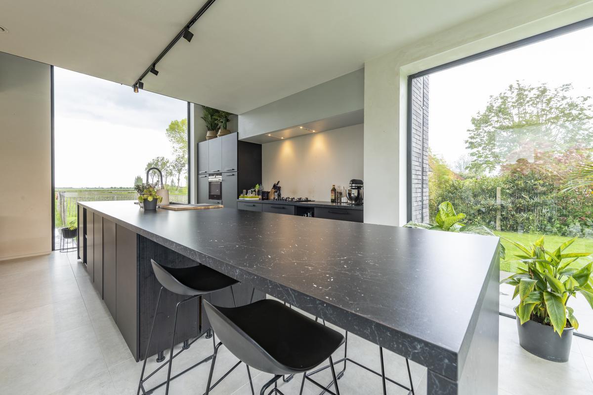De zwarte keuken is een mooie eyecatcher tussen de witte muren.© Pieter Clicteur
