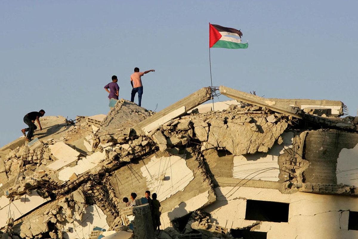 Palestijnen op een vernietigd Joods huis in Gaza, september 2005.