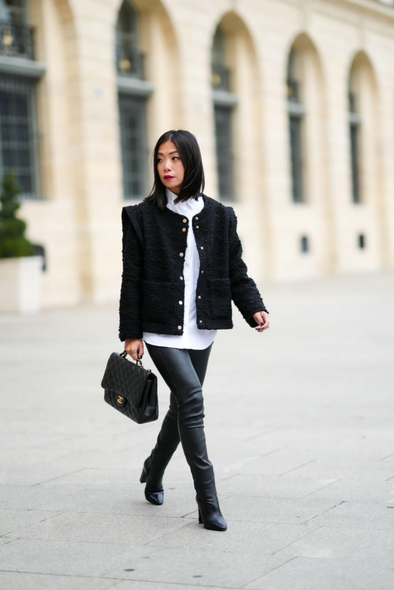 PARIS, FRANCE - OCTOBER 01: May Berthelot wears a white shirt, a black tweed jacket with epaulets, black shiny leather skinny pants, a black shiny leather Chanel handbag, a silver ring, a gold Juste Un Clou ring form Cartier, black shiny leather pointed block heels ankle boots from Yves Saint Laurent / YSL, during Paris Fashion Week - Womenswear Spring Summer 2022, on October 01, 2021 in Paris, France. (Photo by Edward Berthelot/Getty Images)