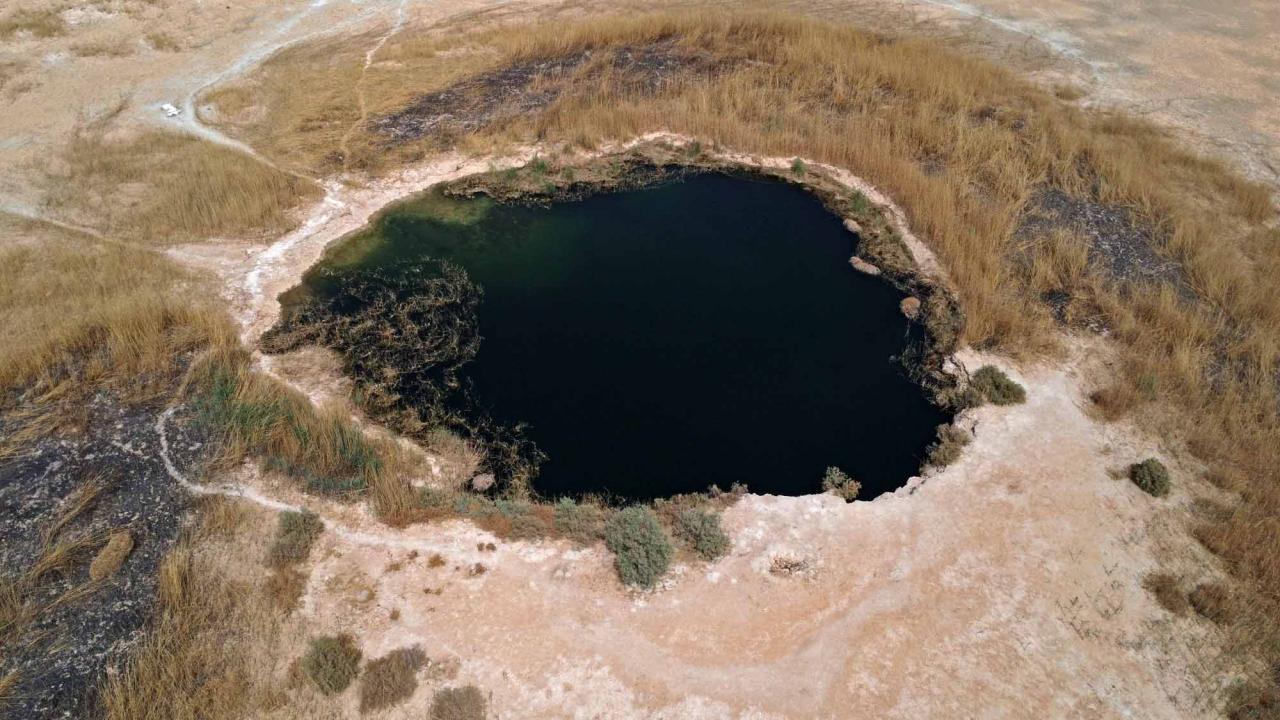An aerial view shows a pond remaining at the dried-up Sawa Lake in Iraq's southern province of al-Muthanna on April 19, 2022. - In Sawa, a sharp drop in rainfall -- now only at 30 percent of what used to be normal for the region -- has lowered the underground water table, itself drained by wells, said a senior advisor at Iraq's water resources ministry. (Photo by Asaad NIAZI / AFP)