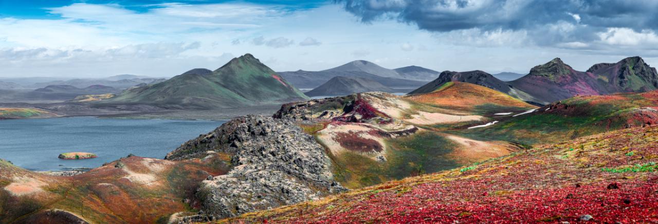 Panoramic landscape view of colorful rainbow volcanic Landmannalaugar mountains, volcanoes, lava fields, crater, water streams and lagoons at blue sky with clouds, Iceland, summer