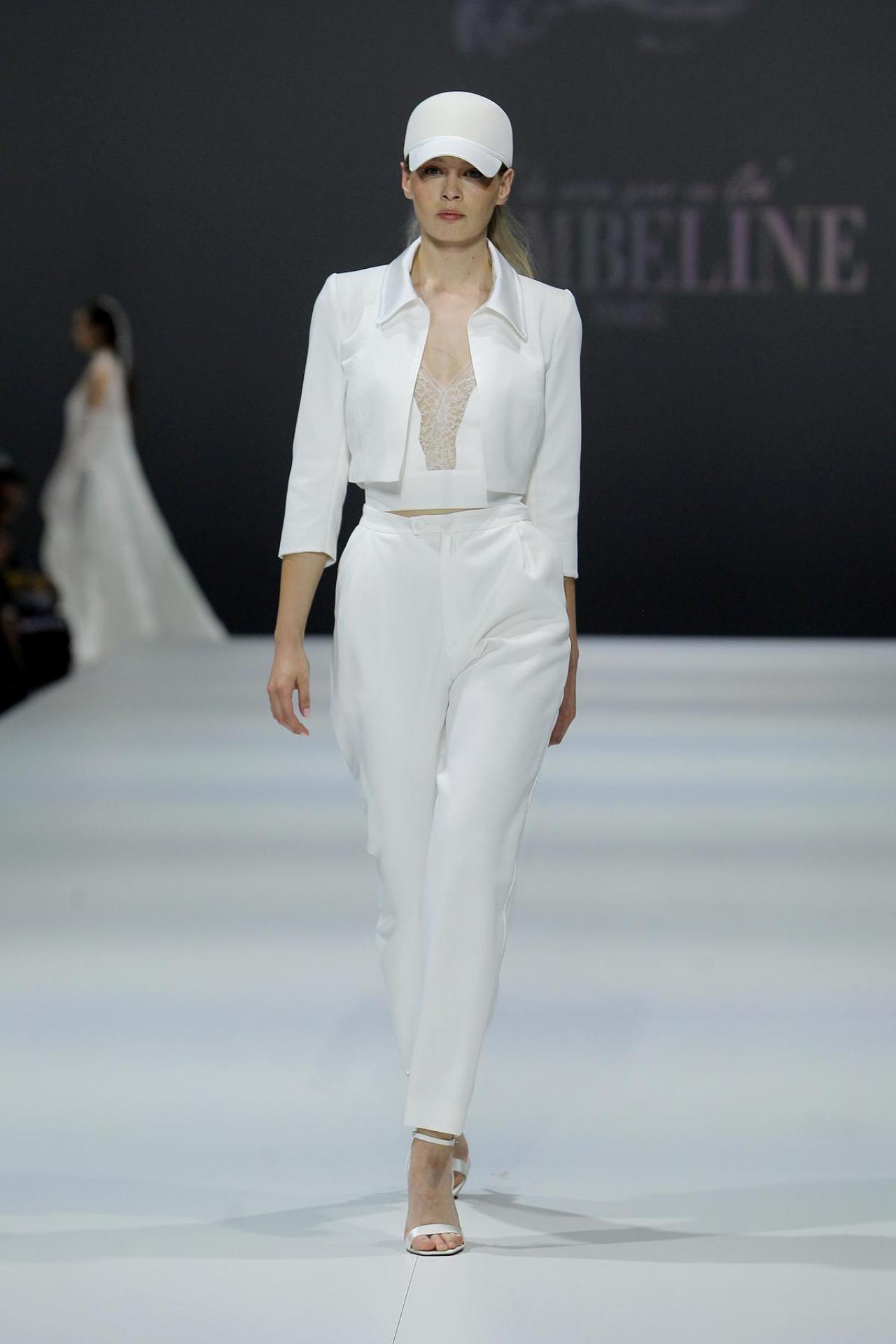 Keep coolVlotte bruidsoutfit, bestaande uit een rechte pantalon, een kort topje met kant en een korte jas, van Cymbeline (prijs op aanvraag).