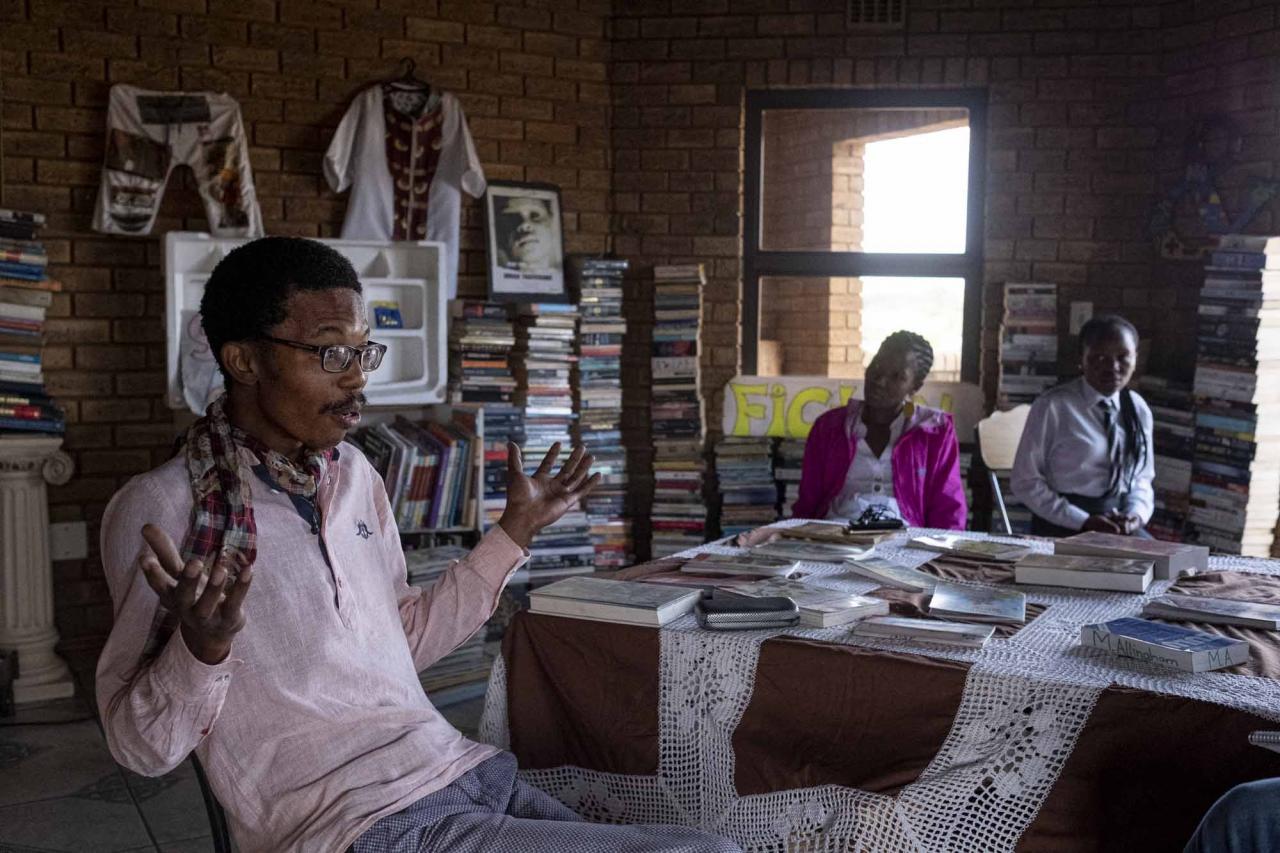 Founder of the Soweto Book Cafe, Thami Mazibuko, gestures in his home in Soweto on April 5, 2022. - In Thami Mazibuko's childhood home, the 36-year-old has turned the upper level into a bookstore and library, seeded with 30 of his own books, now overflowing with hundreds of donations.
After he finished school, he left Soweto and moved into the formerly white suburbs of Johannesburg, where he stayed with relatives who were artists, with a home full of books.
He developed an insatiable appetite for reading, even bring books into the reggae club where liked to listen to music.
When he decided to move back home, he brought his growing personal collection with him.
So began the Soweto Book Cafe, officially founded in 2018. (Photo by EMMANUEL CROSET / AFP)